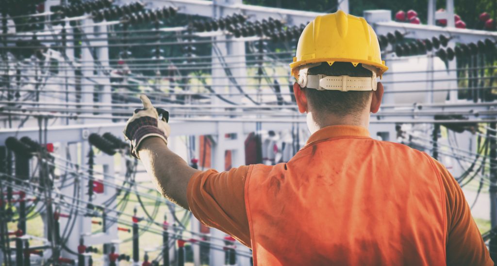 worker with protective uniform in front of power plant - toned image, retro film filtered in instagram style