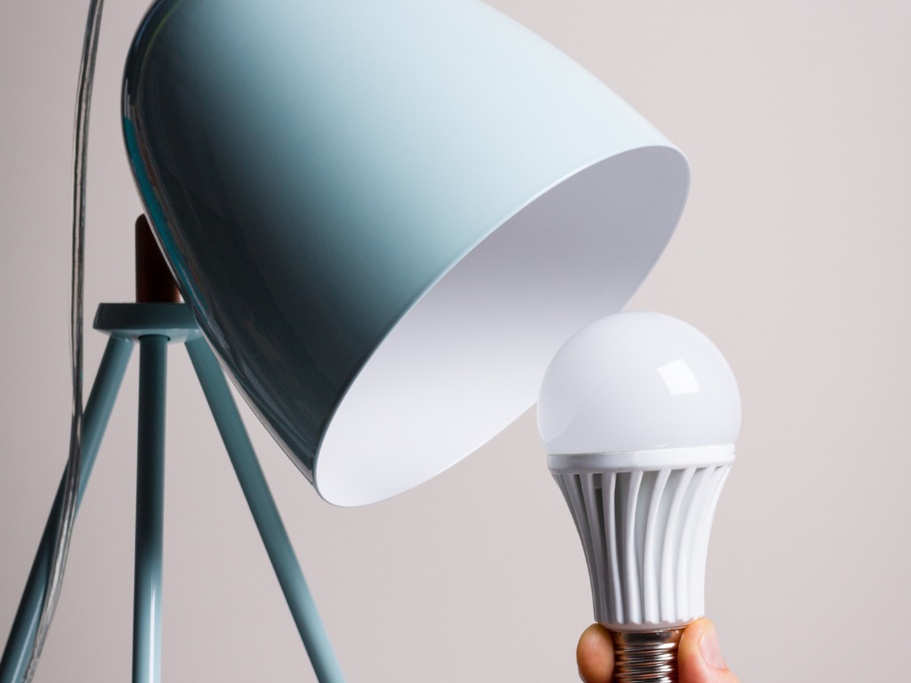 changing-the-bulb-for-led-bulb-in-table-lamp-in-turquoise-colours-picture-id848061646