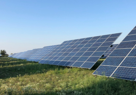 solar panels in a field with green grass and a blue sky