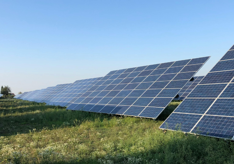solar panels in a field with green grass and a blue sky